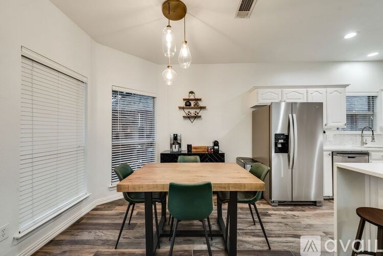 A dining area with a wooden table and green chairs.