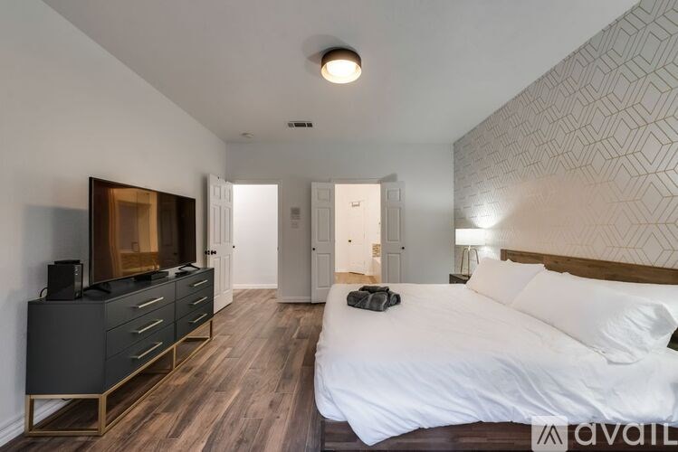 A bedroom with a large bed and a TV cabinet.