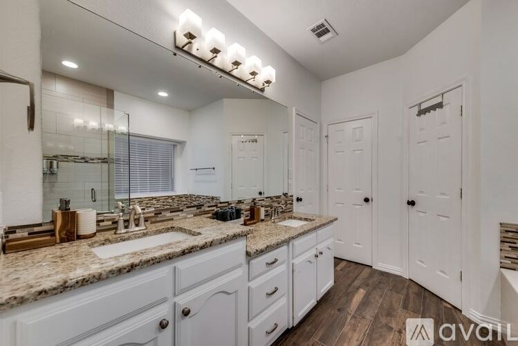 A bathroom with a vanity, sink, and mirror.