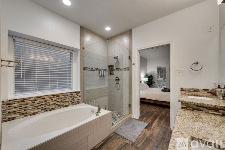 A modern bathroom with a stone wall and a large tub.
