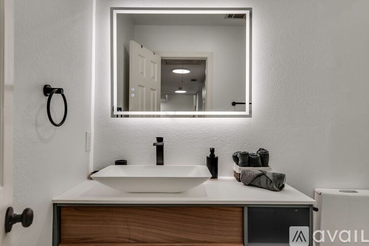A bathroom with a sink, mirror, and towel.
