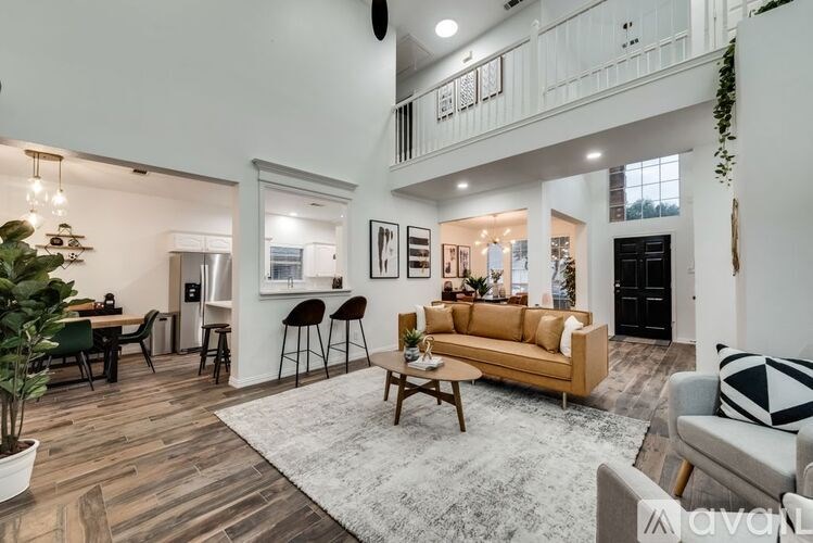 A living room with a couch, chairs, and a dining table.