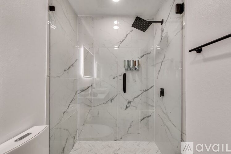 A bathroom with marble tiles and a walk-in shower.