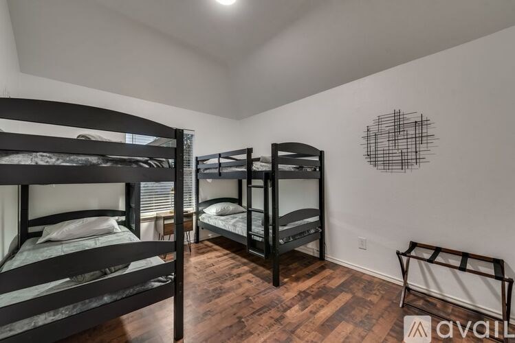 A room with bunk beds and a wooden floor.