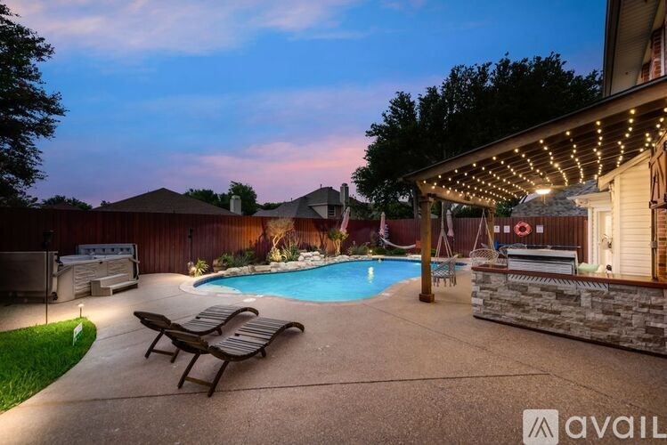 A backyard with a pool and patio furniture.