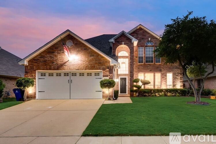 A house with a garage and a tree in front.
