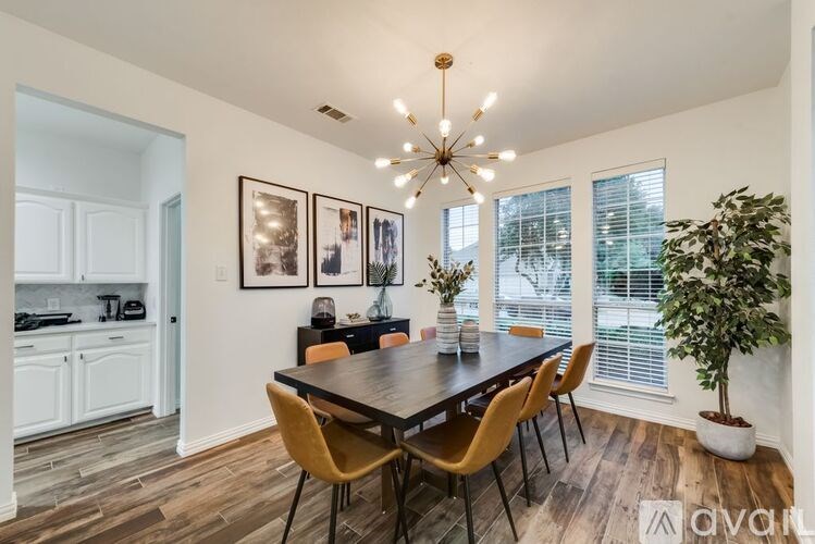 A dining room with a wooden table and chairs.