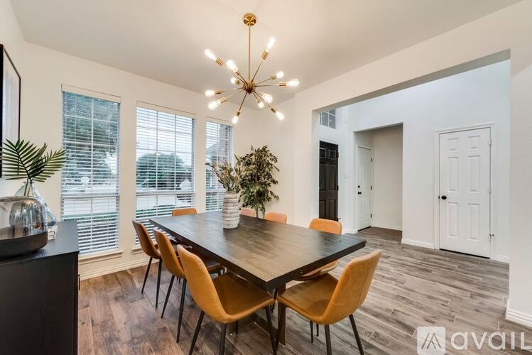 A dining room with a wooden table and chairs.