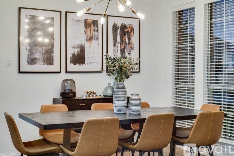 A dining room with a table, chairs, and pictures on the wall.