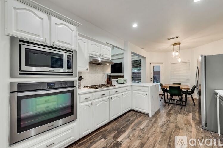 A modern kitchen with stainless steel appliances and white cabinets.