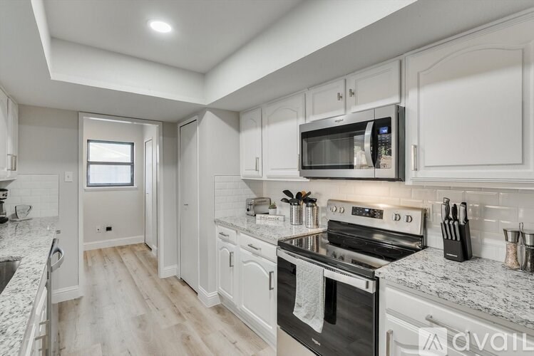 A modern kitchen with white cabinets and a black oven.