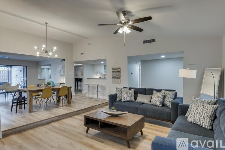 A spacious living room with a grey sofa and a wooden coffee table.