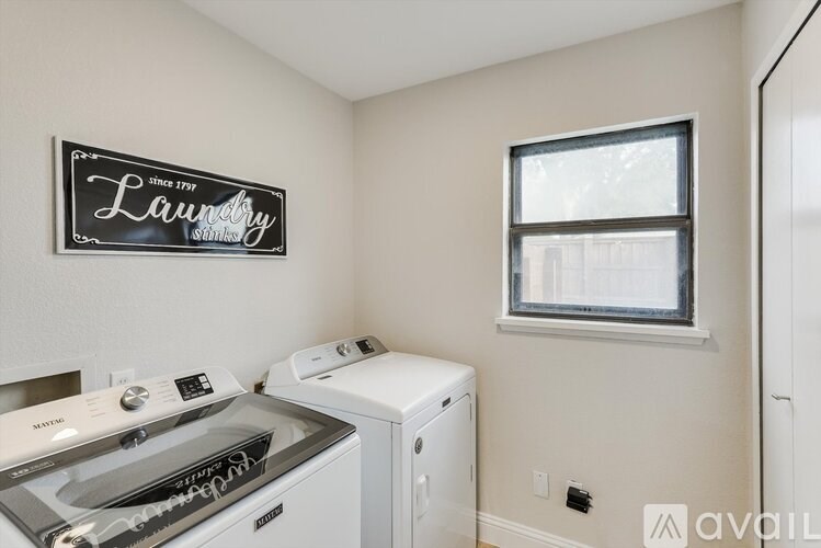 A laundry sign is on the wall above a washer and dryer.
