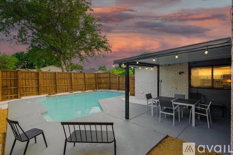 A backyard with a pool, patio furniture, and a house.