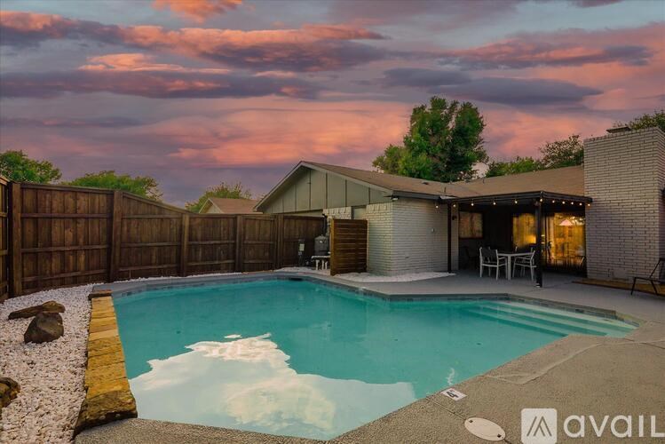 A backyard with a pool and a house.