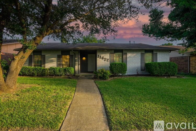 A house with a tree in front of it and a sidewalk leading to the front door.