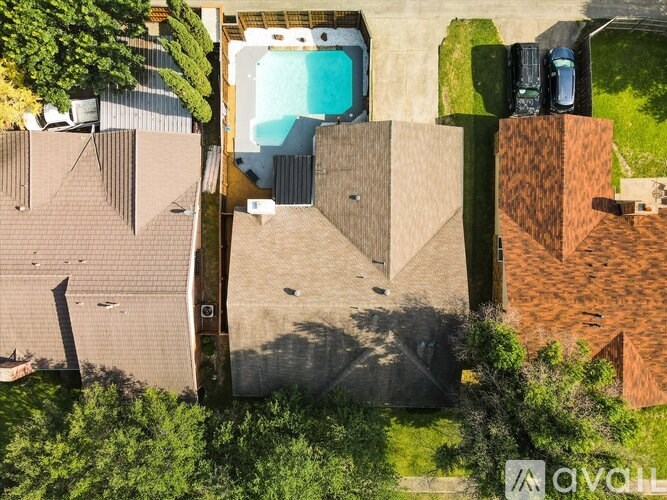 A bird's eye view of a house with a swimming pool and a car parked in the driveway.