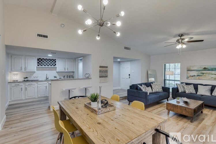 A modern open plan living and dining area with a wooden table and yellow chairs.