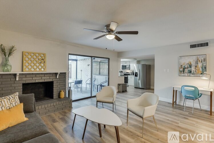 A living room with a fireplace and a dining area in the background.
