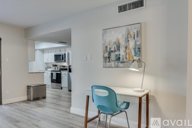 A blue chair sits in front of a desk with a lamp on it.