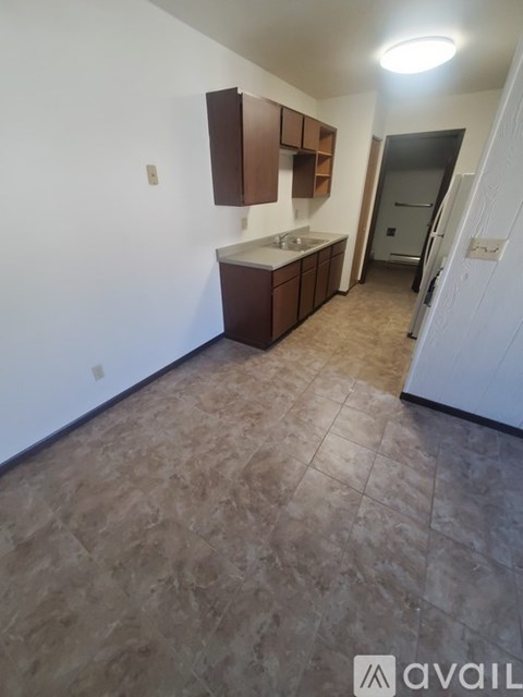 A kitchen area with brown cabinets and a tiled floor.
