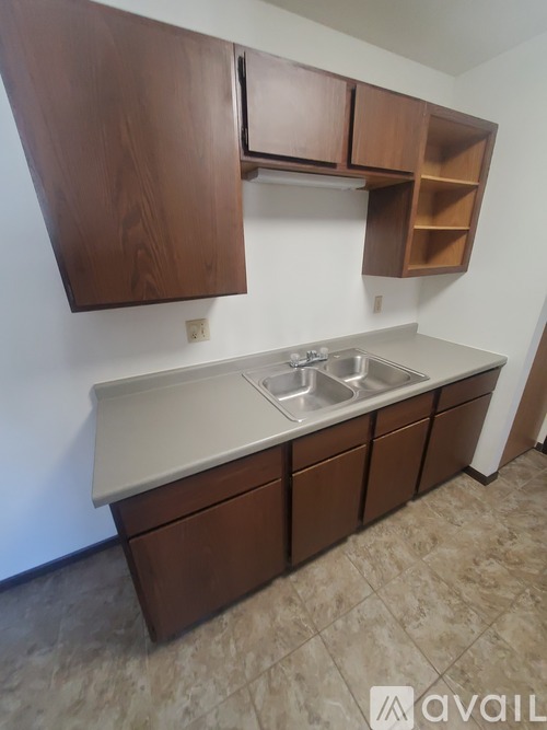 A kitchen with brown cabinets and a marble countertop.