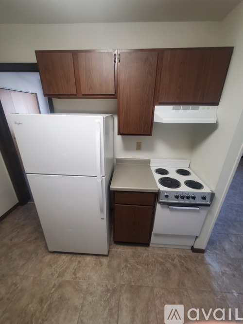 A small kitchen with a white refrigerator and a white stove top oven.