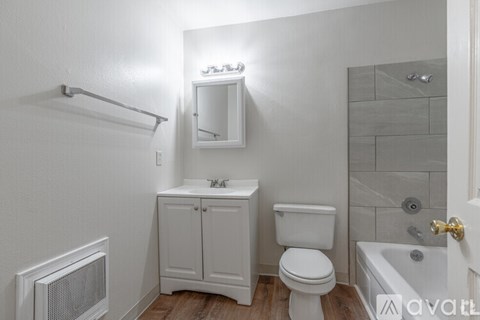 A white bathroom with a toilet, sink, and bathtub.