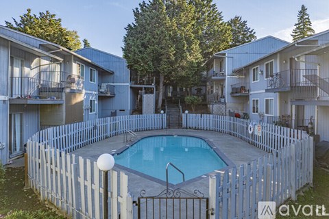 A small pool surrounded by a white picket fence.