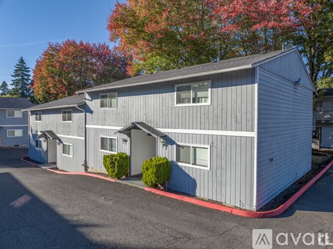 A grey house with a red border around the driveway.