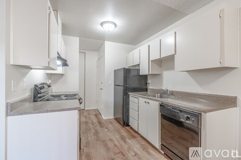 A kitchen with white cabinets and a granite countertop.
