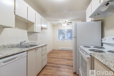 A kitchen with white appliances and cabinets.