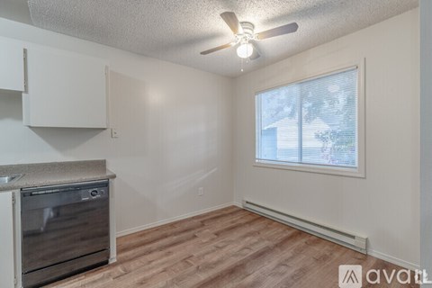A room with a window and a fan on the ceiling.