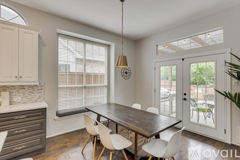 A dining room with a wooden table and chairs.