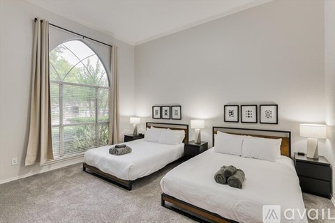 Two twin beds in a bedroom with a window and a carpet.