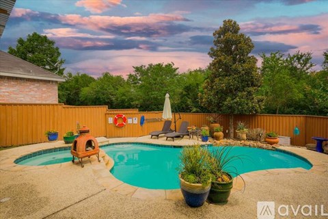 A backyard with a pool and patio furniture.