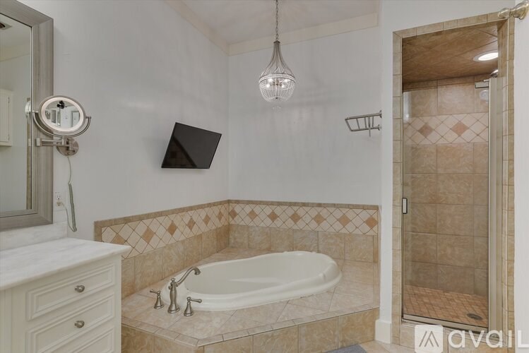 A bathroom with a tiled floor and a white bathtub.