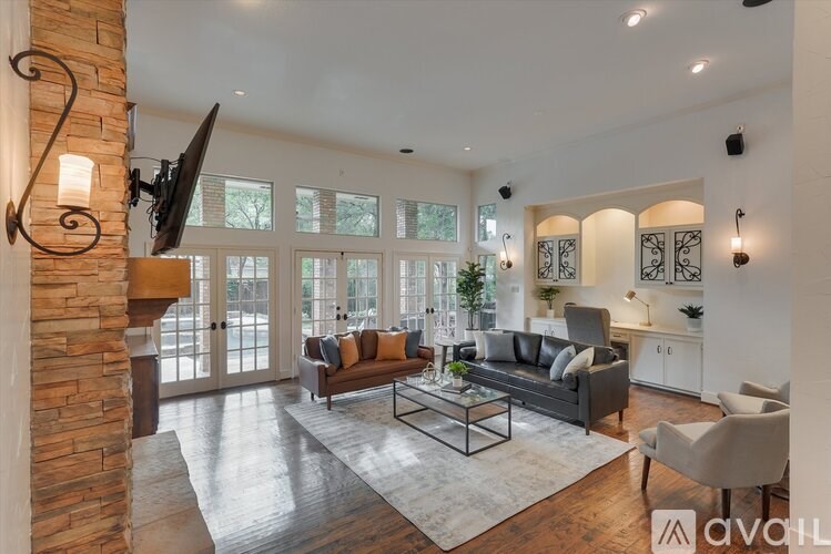 A modern living room with a stone pillar and a large sectional sofa.