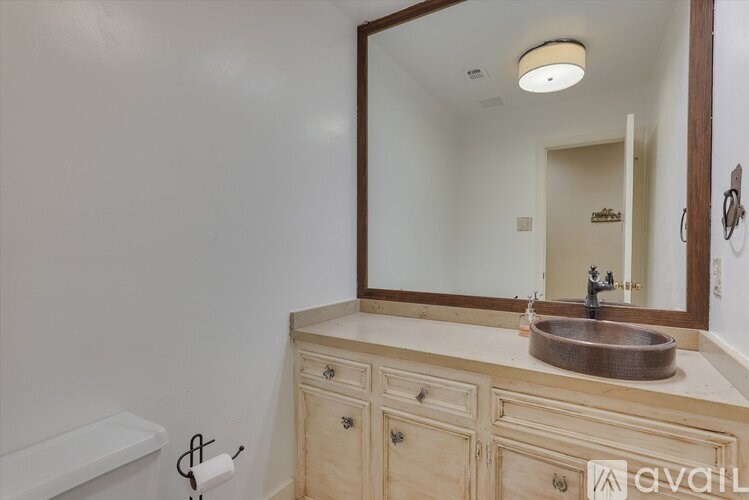 A bathroom with a wooden vanity and a large mirror.