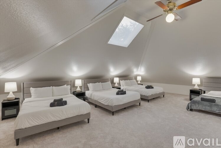 A room with four beds and a ceiling fan.