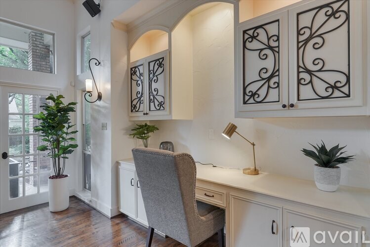 A room with a desk, chair, and cabinets with decorative designs.