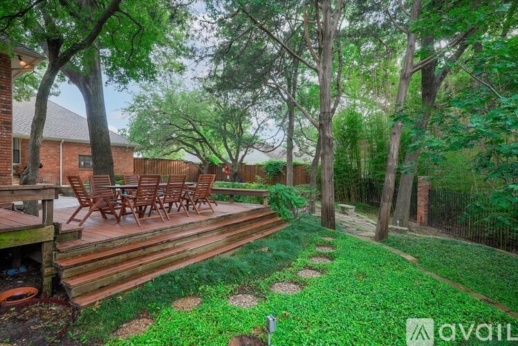 A backyard with a deck and a fence.