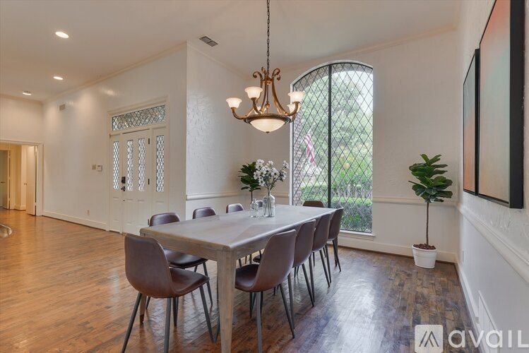 A dining room with a table set for six with chairs around it.