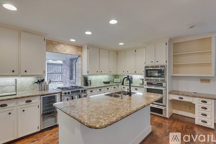 A kitchen with granite countertops and white cabinets.