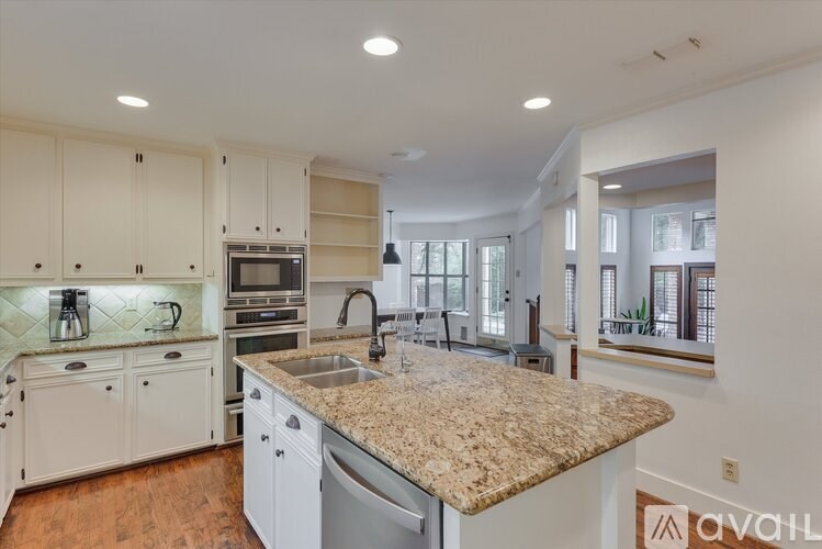 A kitchen with granite countertops and white cabinets.