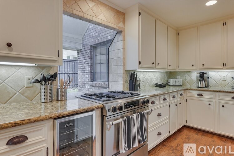 A kitchen with white cabinets and a granite countertop.