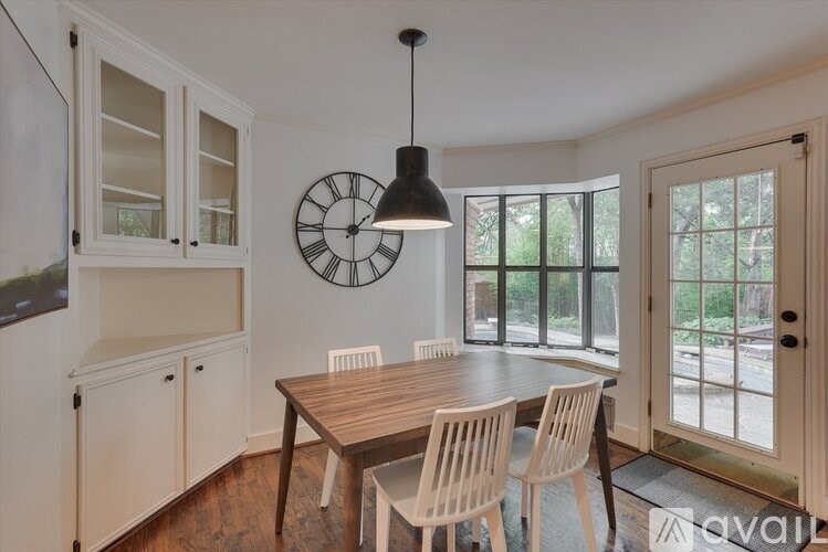 A dining room with a wooden table and chairs.