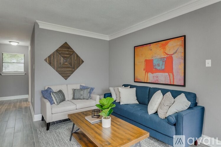 A living room with a blue couch and a wooden coffee table.