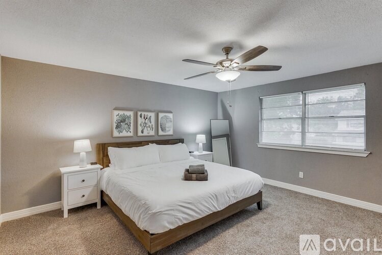 A bedroom with a bed, nightstand, and a ceiling fan.