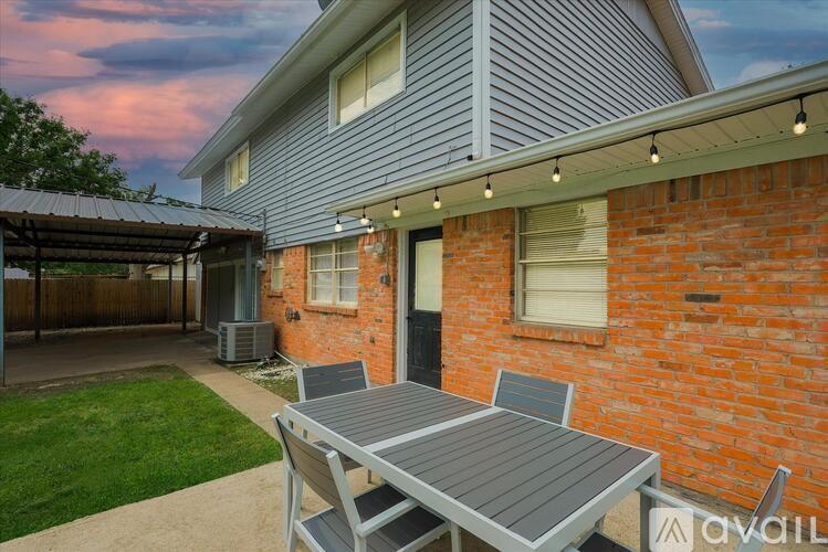 A patio with a table and chairs is set up outside a house.